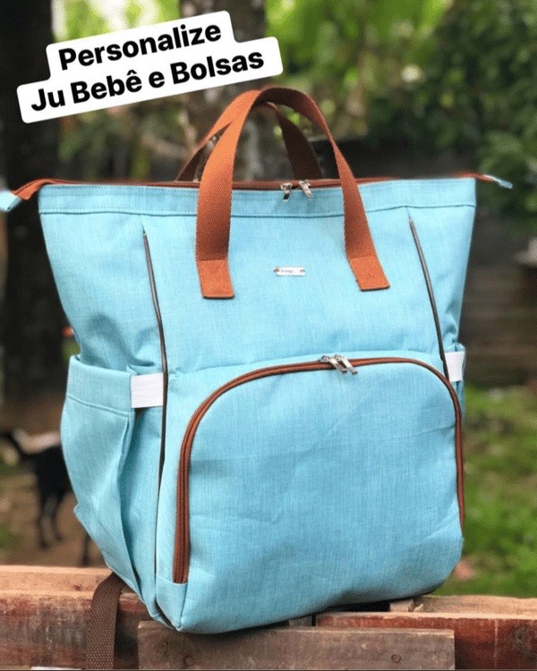 Mochila multifuncional em tecido azul-claro com alças em couro caramelo